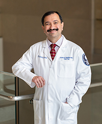 Dr. Neville Dossabhoy next to a flight of stairs in the School of Medicine.